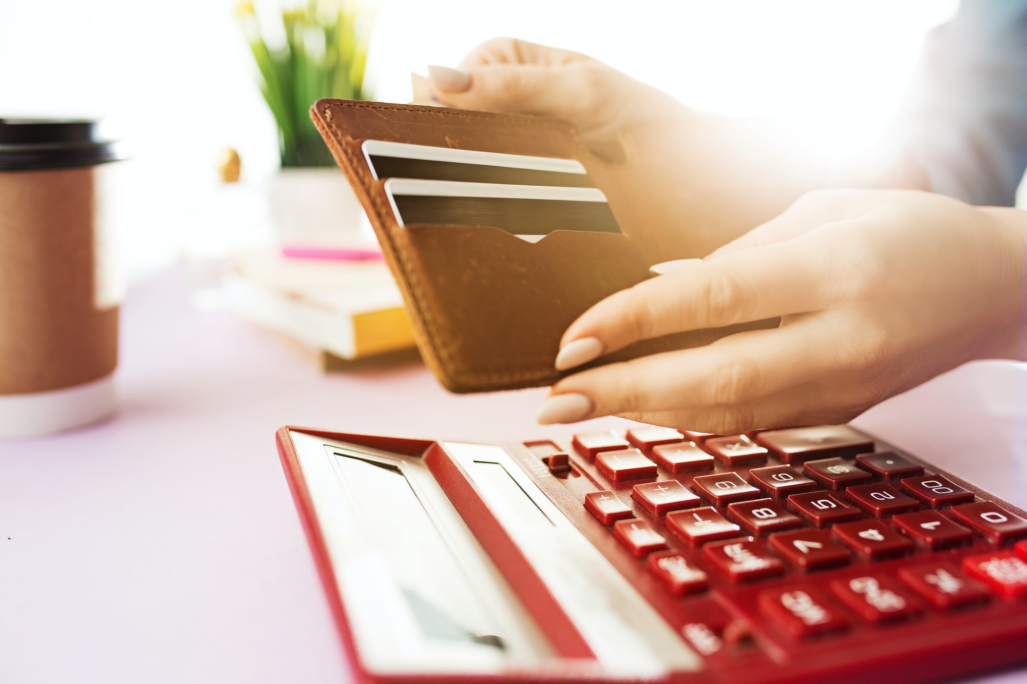 woman is holding purse, credit card in hands and calculating the costs